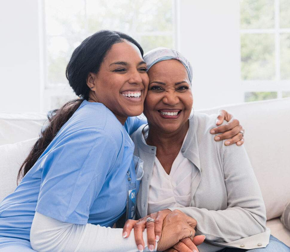 A caregiver and nurse smiling together