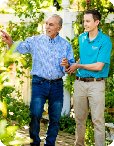 A caregiver with an elderly man smiling