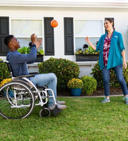 A caregiver playing outside with a child