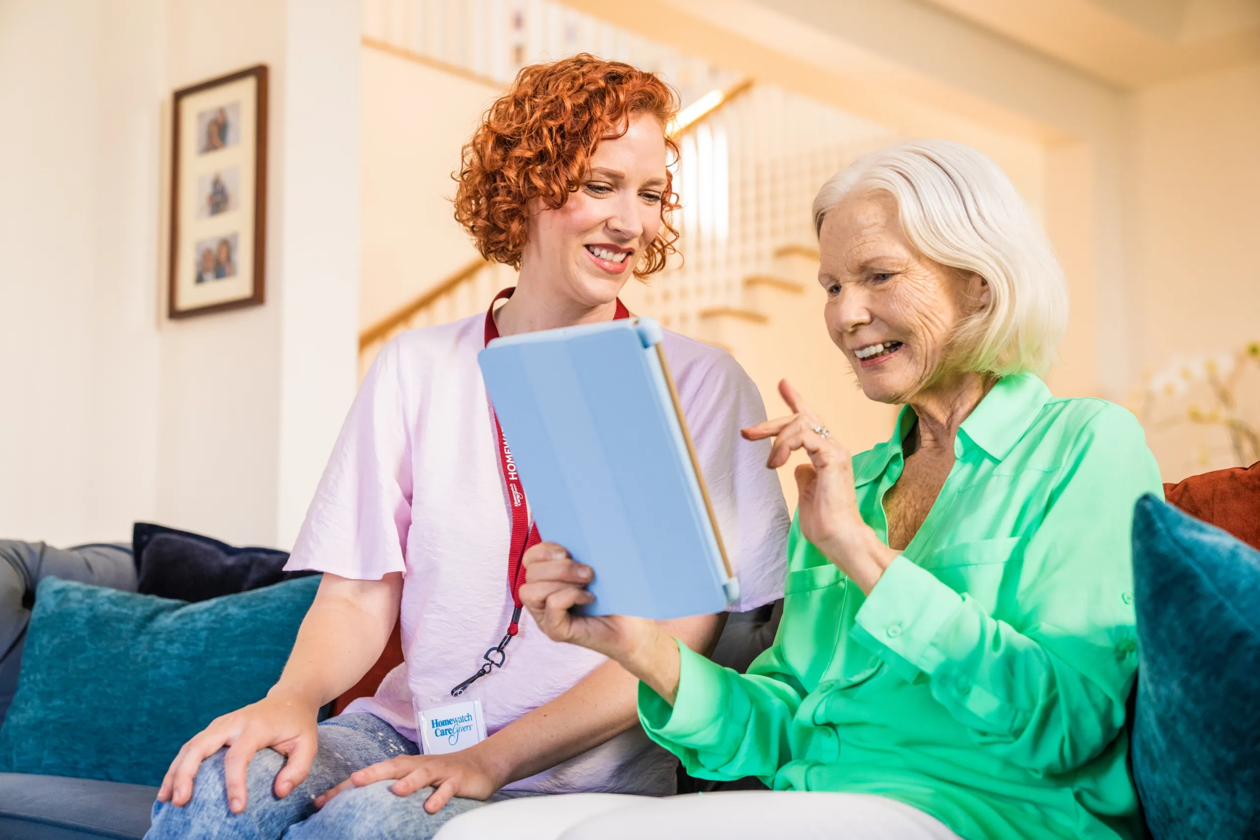 A caregiver sitting with a patient using a tablet