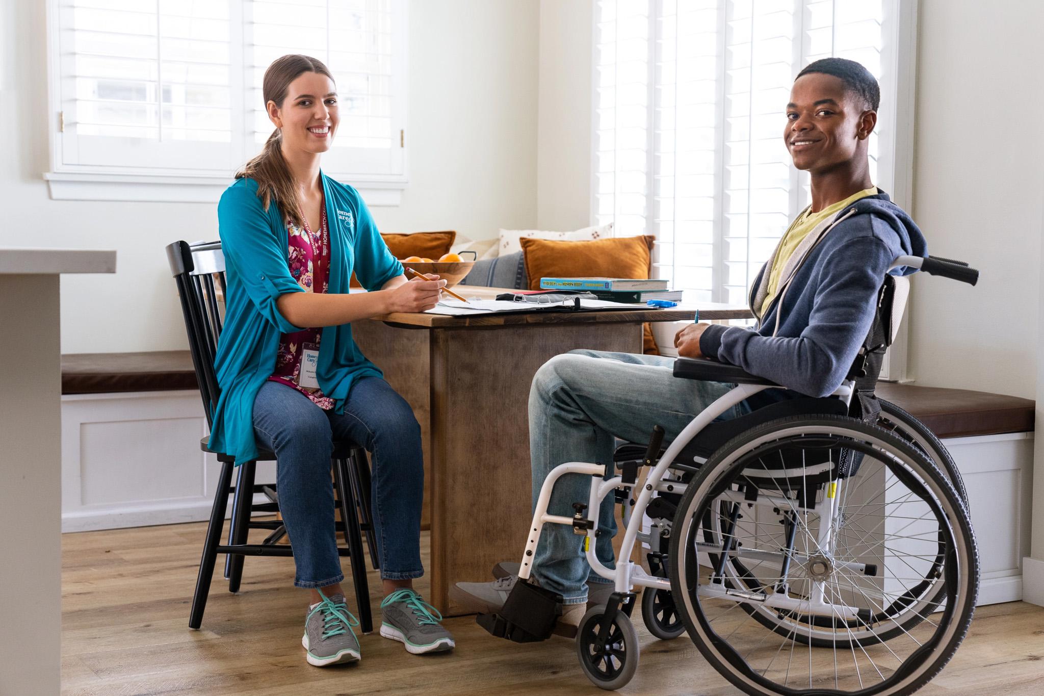 A caregiver sitting with a patient in a wheelchair