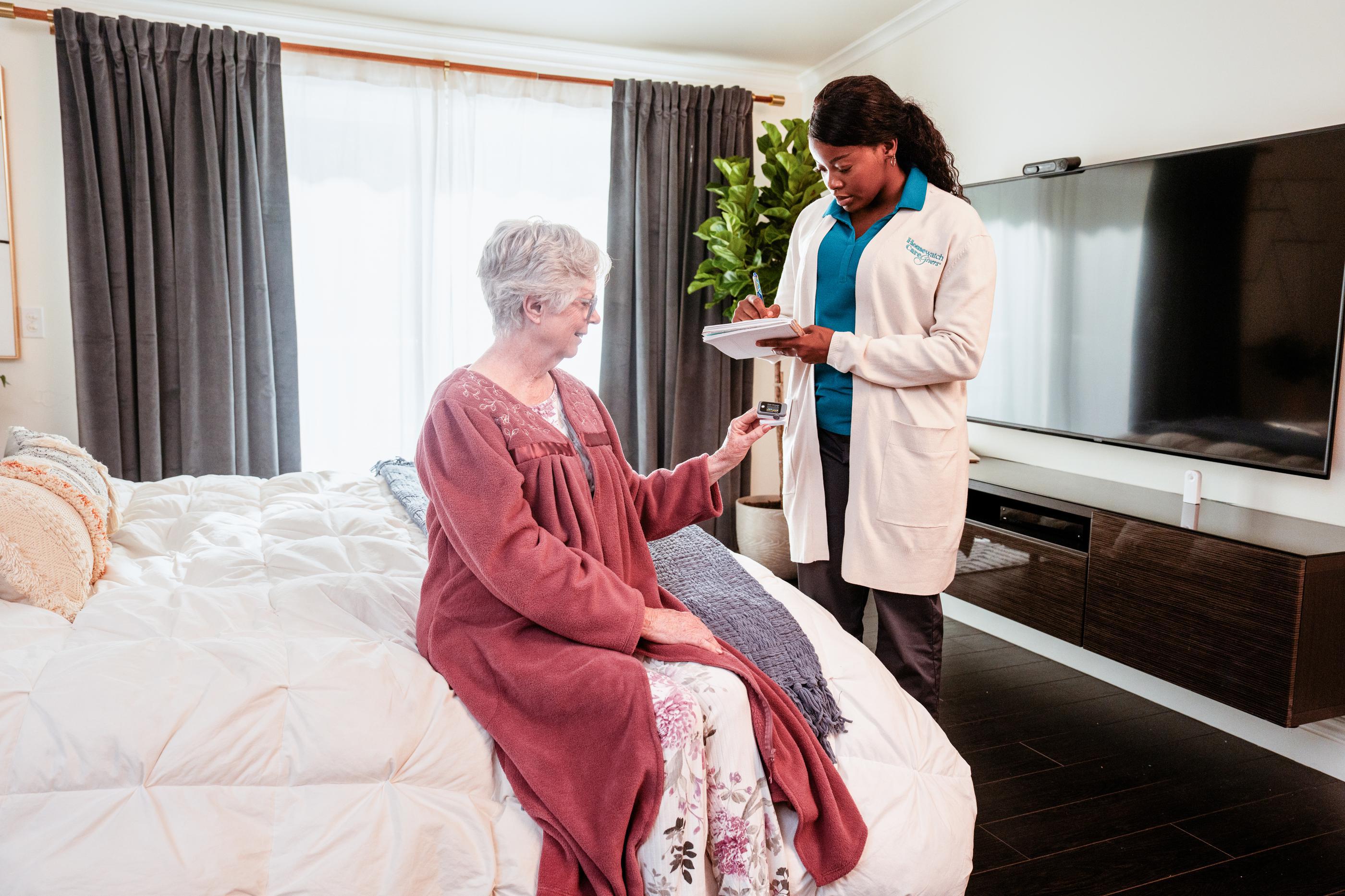 older woman sitting on bed with doctor in room