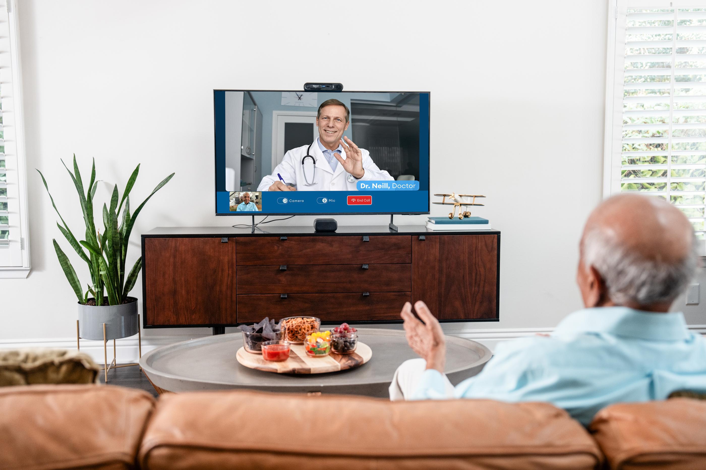 man sitting on couch talking to doctor virtually