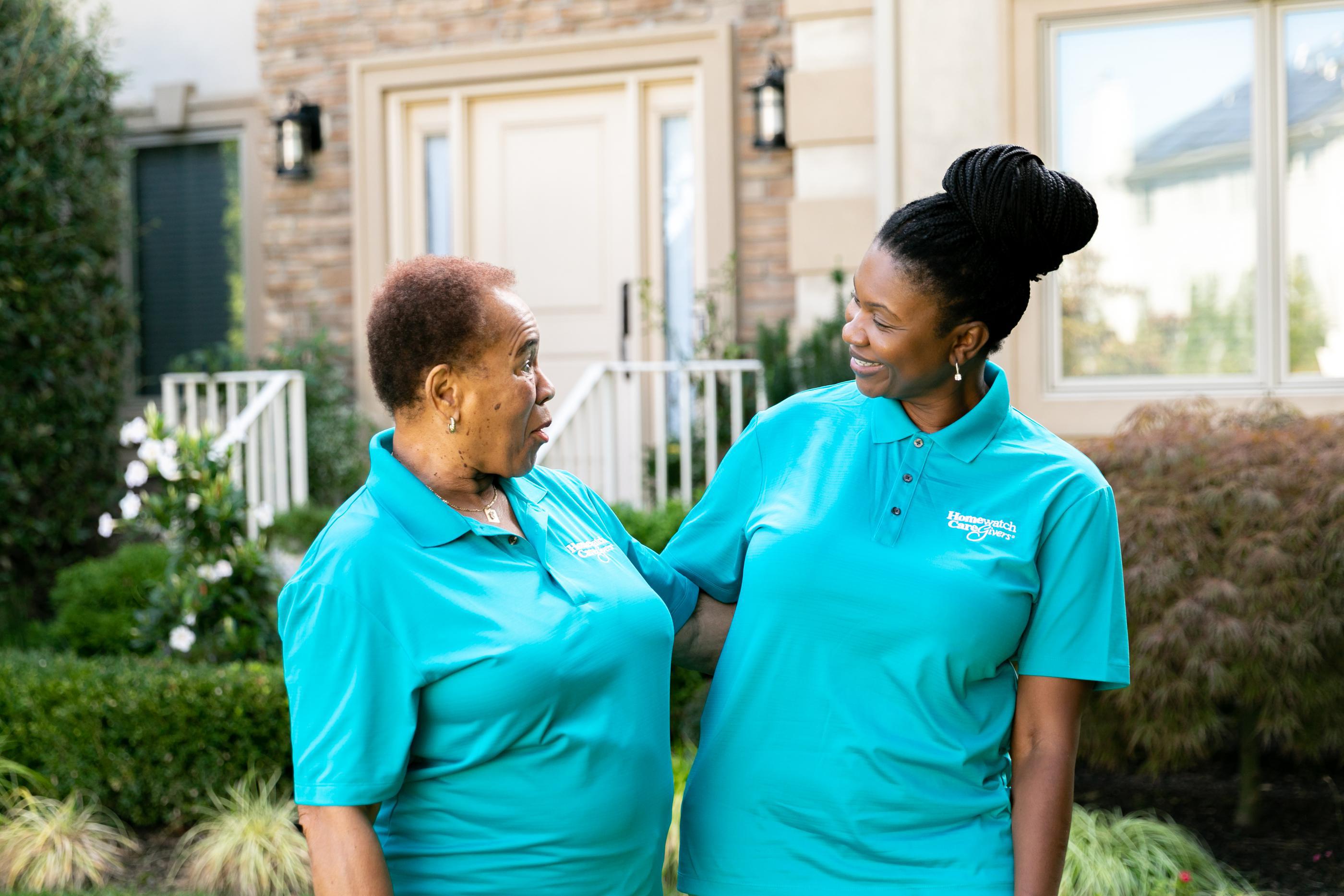 two caregivers looking and smiling at eachother