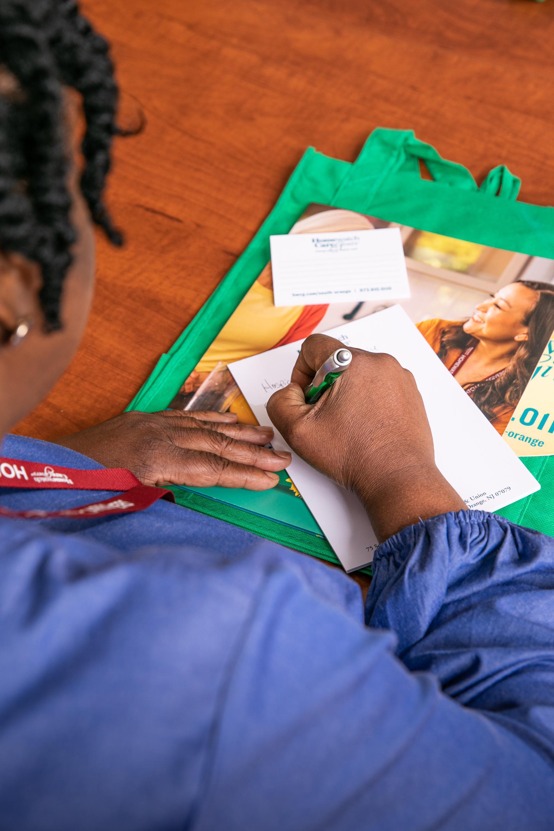 woman writing a note at a table