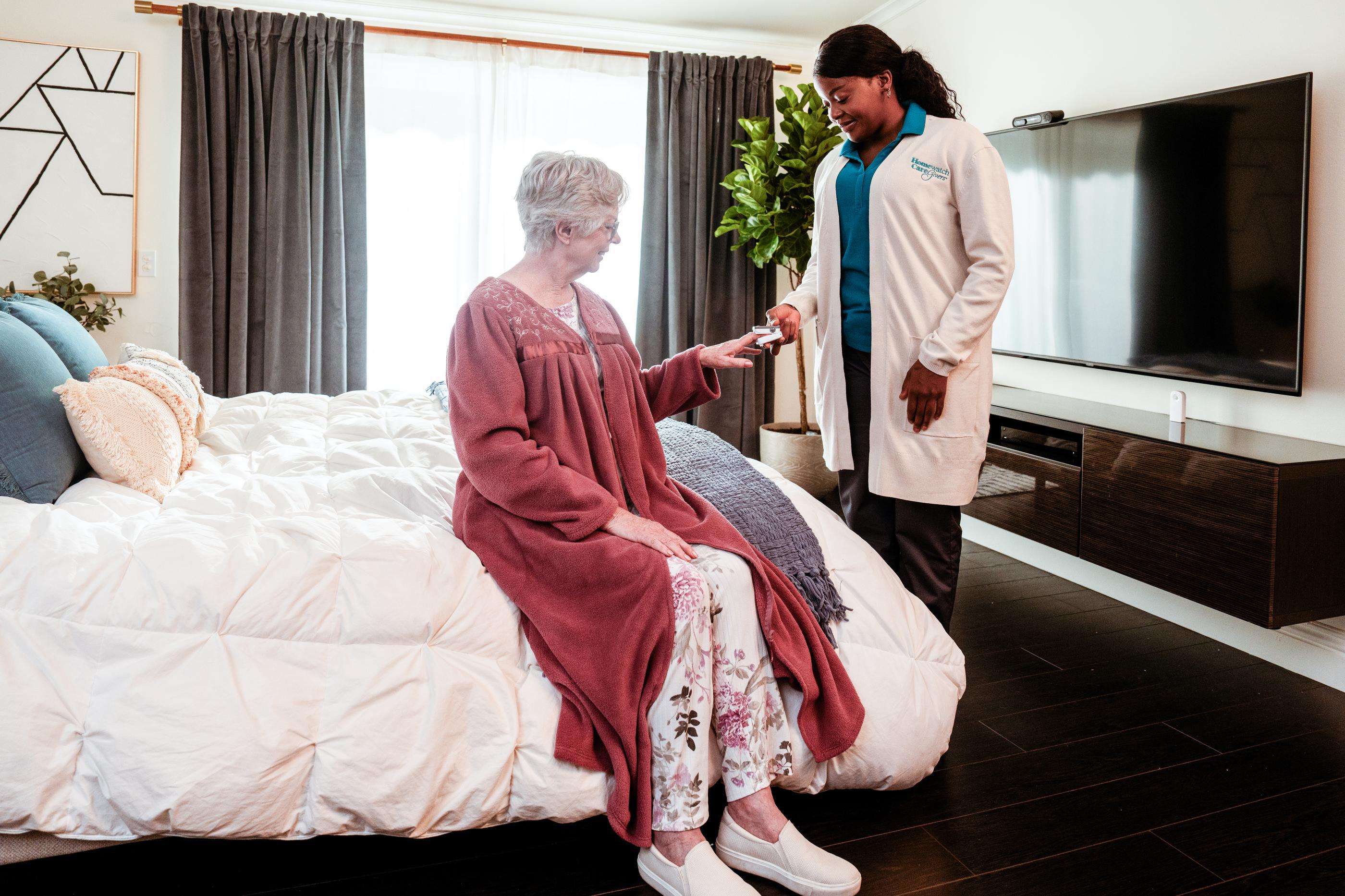 woman sitting on bed with doctor beside her