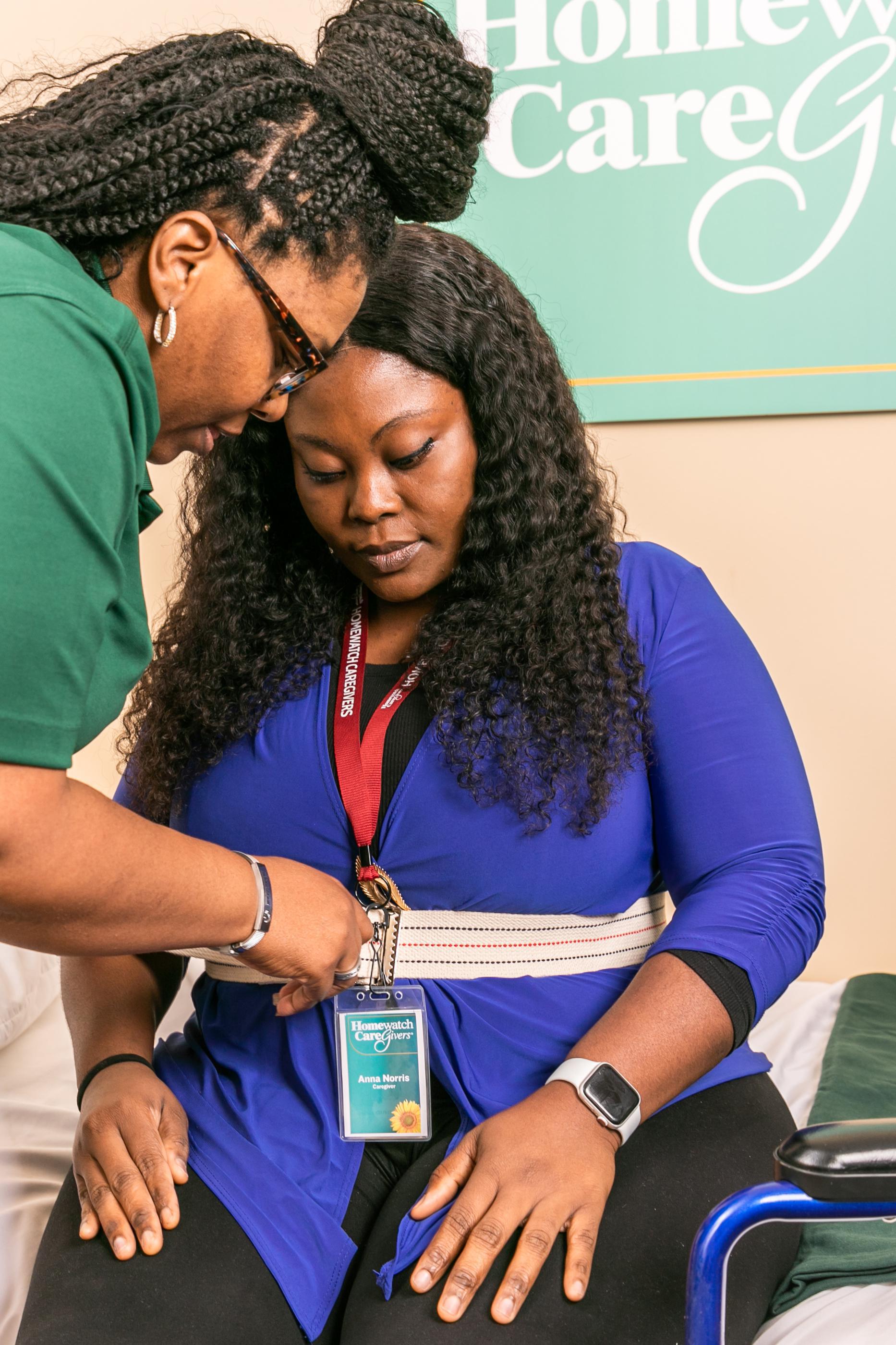woman holding fabric around another woman's waist