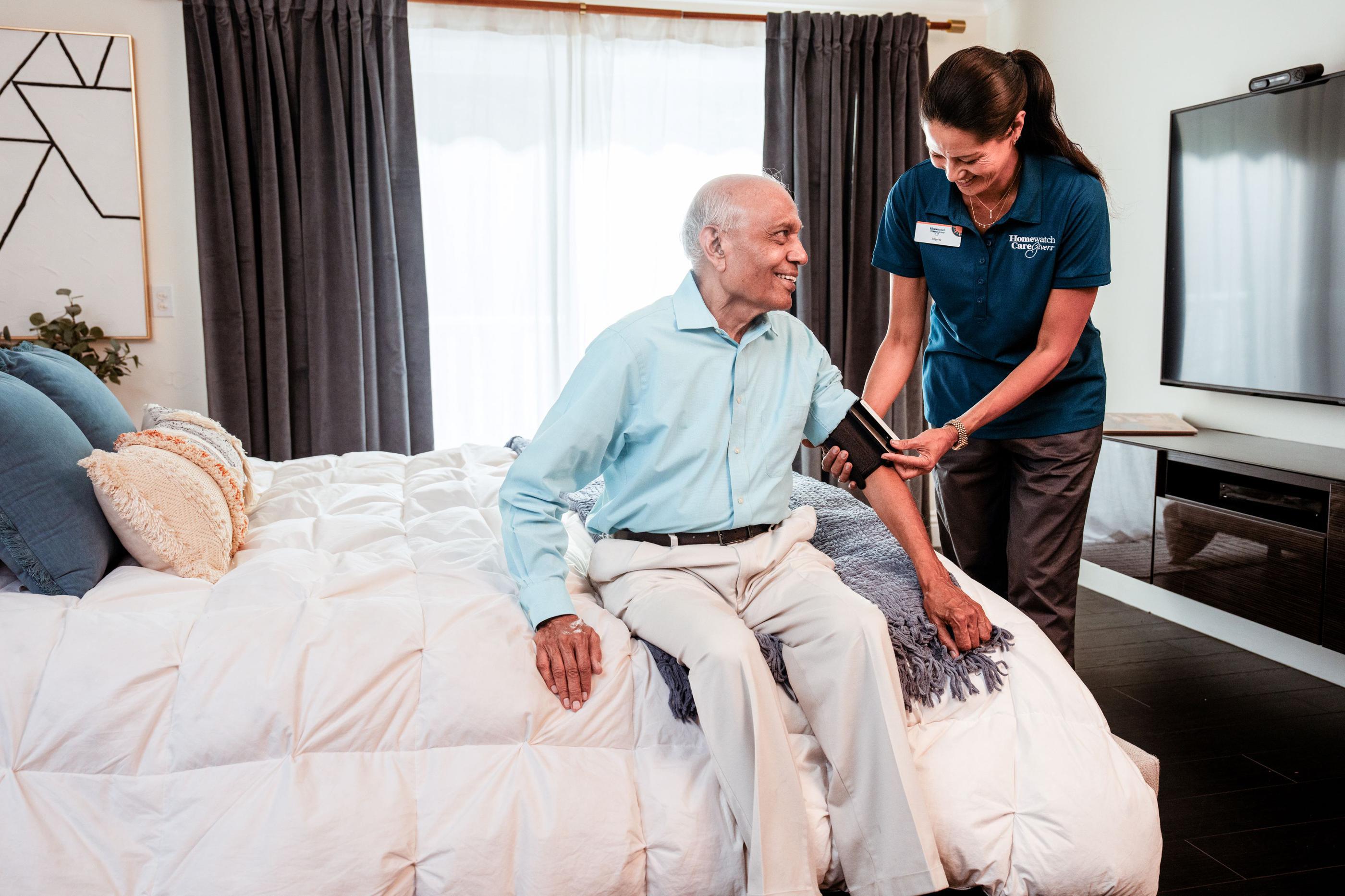 caregiver taking mans blood pressure