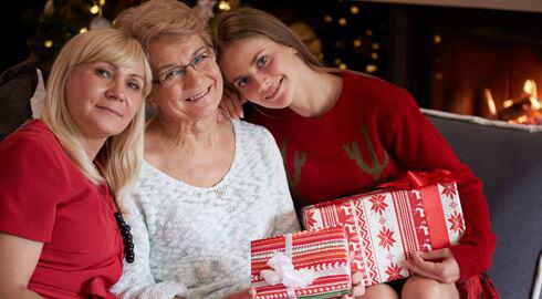 Three women on a sofa with Christmas presents
