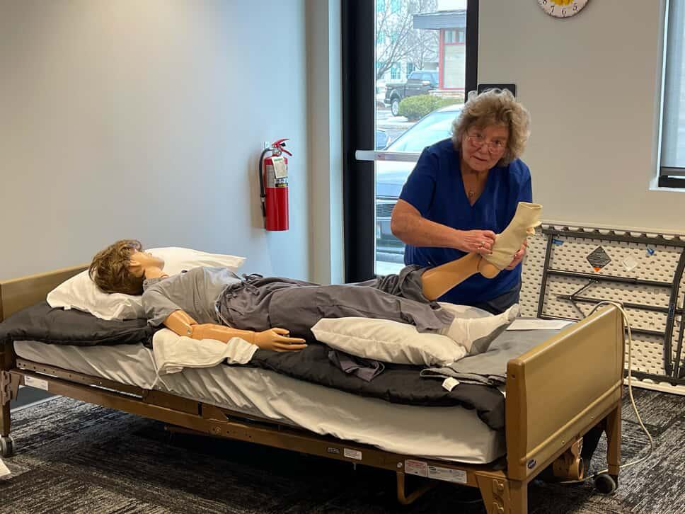 instructor putting bandage on training dummy