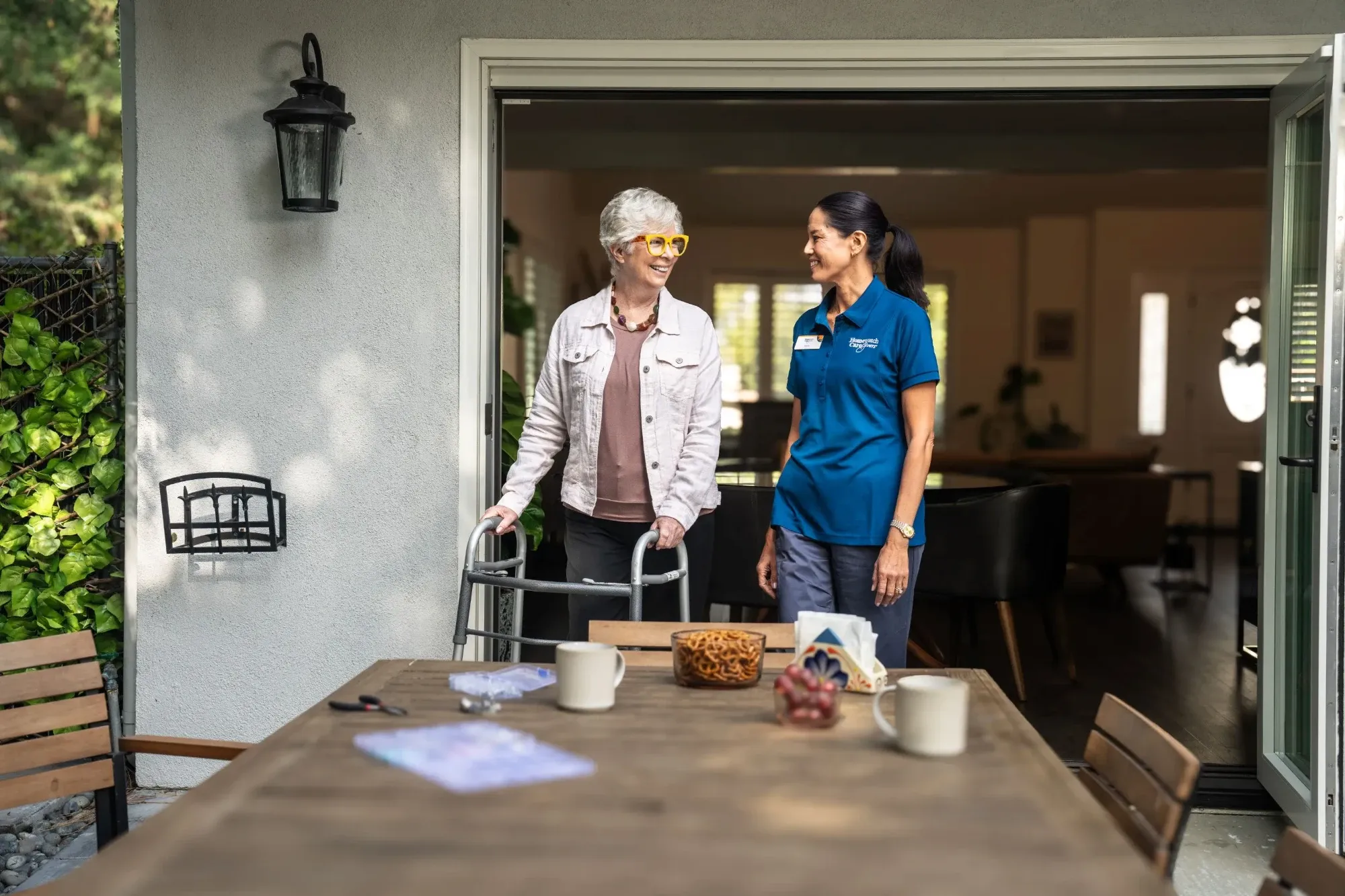 Woman and caregiver standing a the end of table