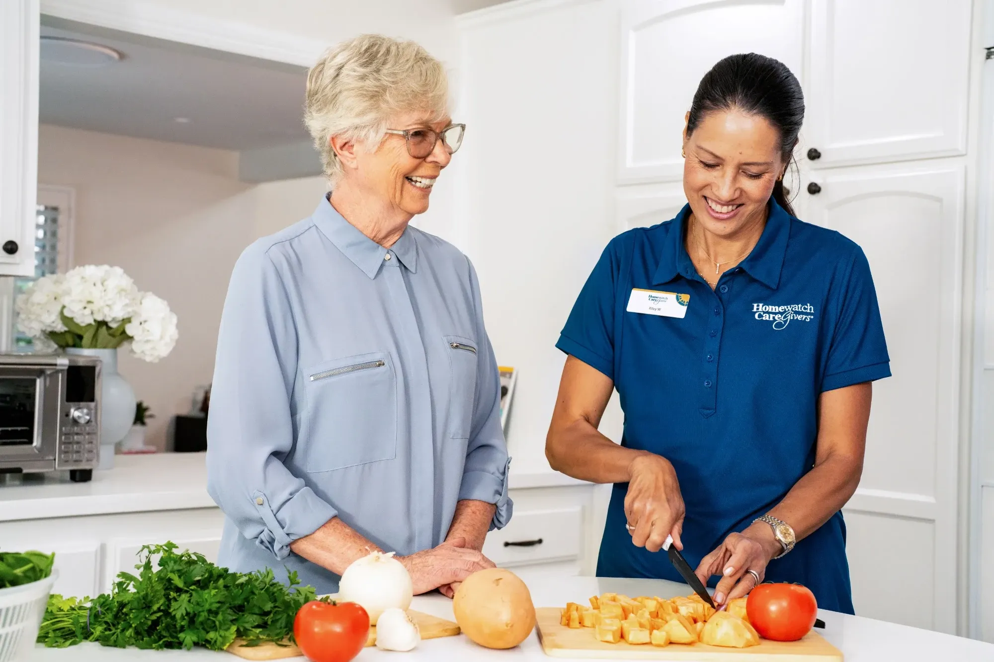 Woman and caregiver cutting vegetables