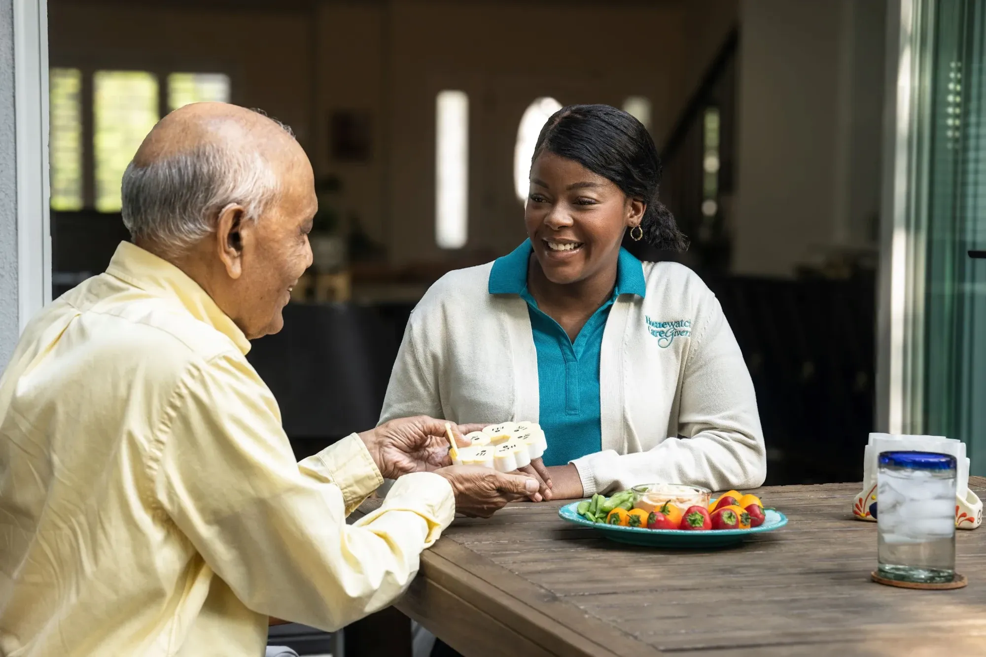 Man and caregiver talking at table