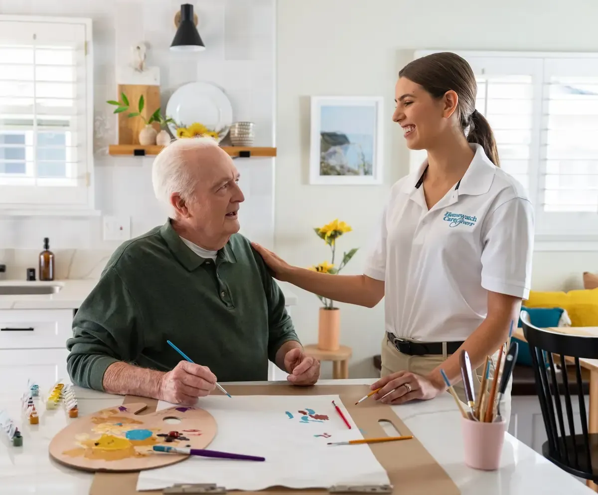 Man painting with caregiver