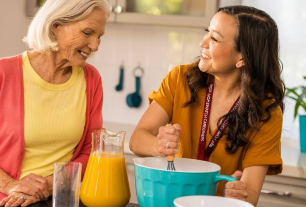 women smiling and cooking in kitchen