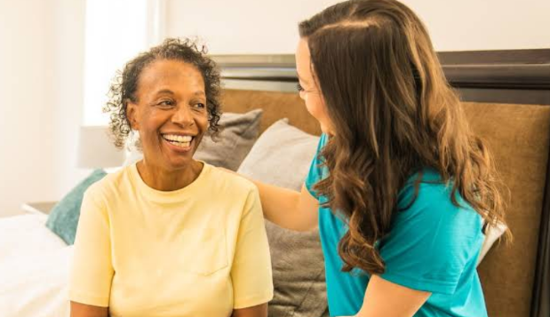 women smiling at each other while sitting on a bed