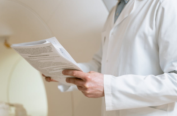 person in white coat holding paperwork