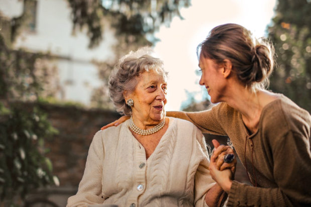 woman sitting, looking at each other and holding hands