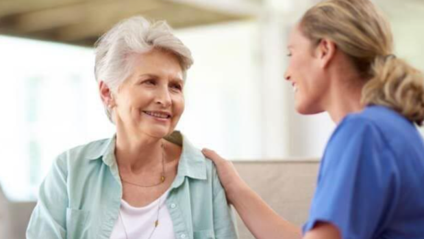 nurse smiling and touching woman's shoulder