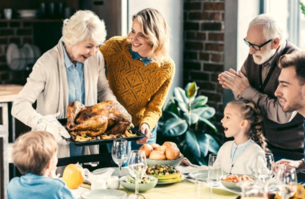 woman setting turkey on table full of people