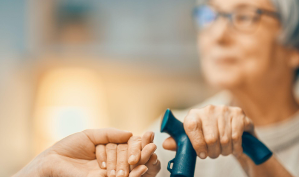 unfocused image of woman smiling holding cane and another persons hand