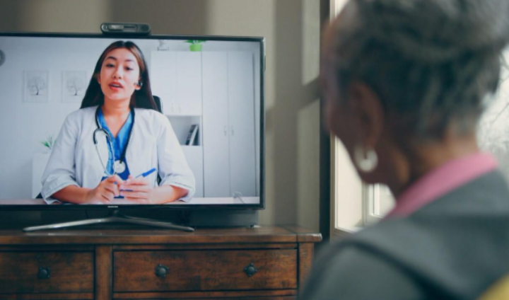 woman looking at screen with doctor on it