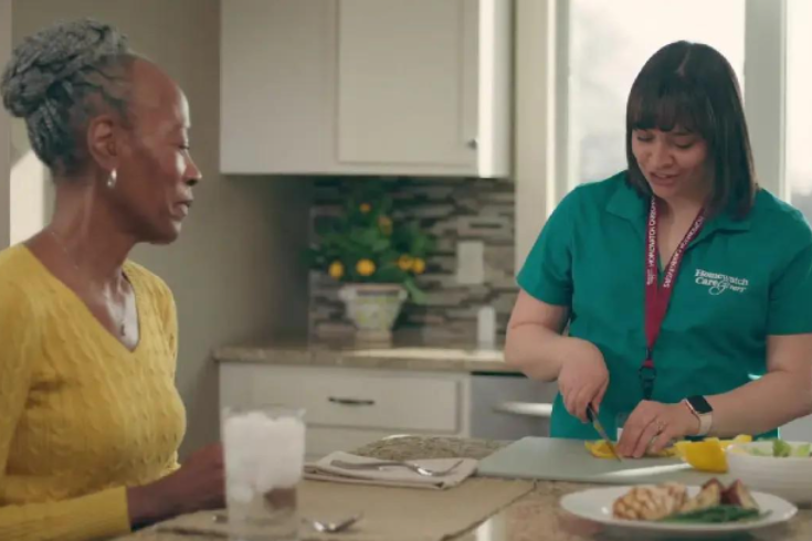 caretaker cutting vegetables while woman watches