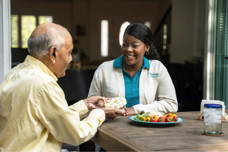 caretaker smiling at man taking pills out of container