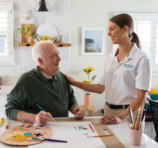 caregiver smiling with hand on man's shoulder