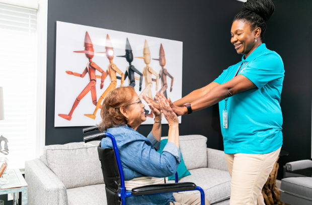 caregiver high fiving woman in wheelchair
