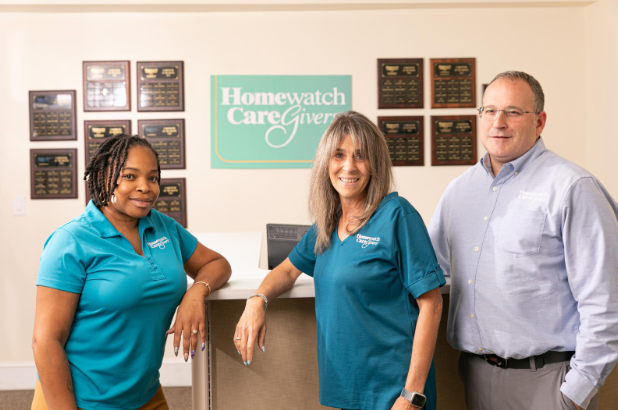 Three Homewatch CareGivers employees standing and smiling