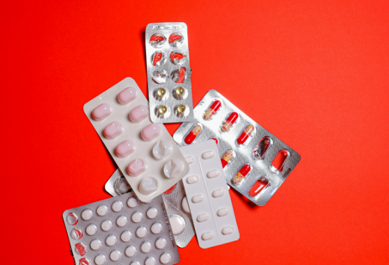 open pill packs laying on red background
