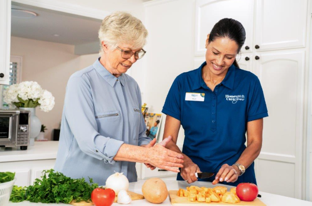 woman and caregiver cutting up vegetables