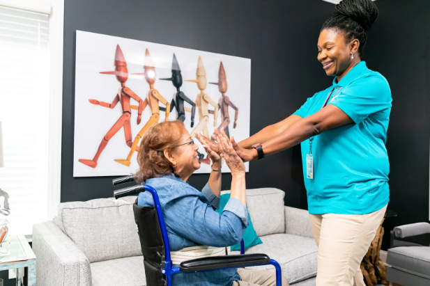 woman in wheelchair high fiving caregiver