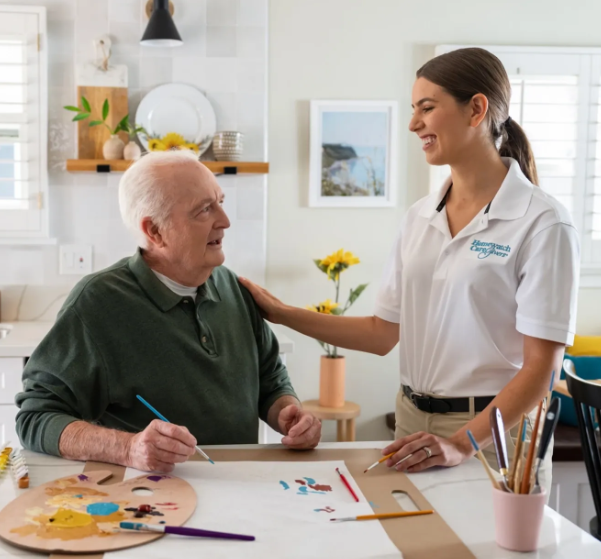 caregiver smiling at man painting