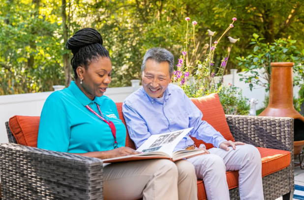 caregiver and man sitting on outdoor couch