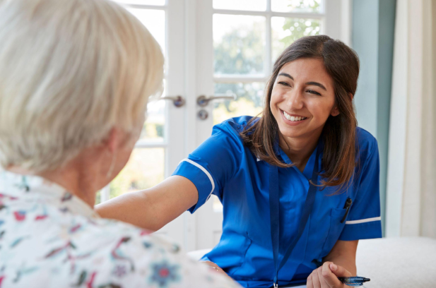 caregiver smiling and holding woman's shoulders