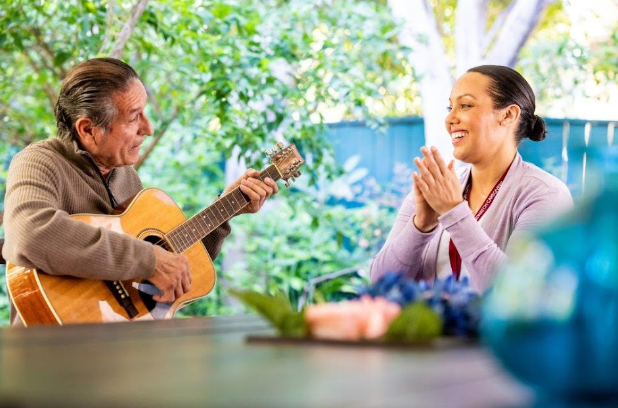 man playing guitar with woman clapping