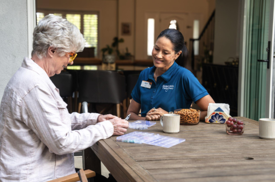 caregiver helping woman with pill management