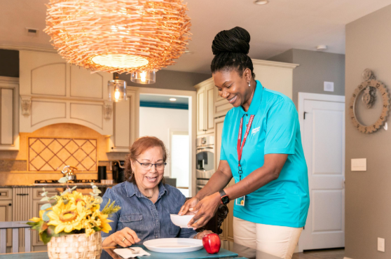 caregiver setting food in front of woman