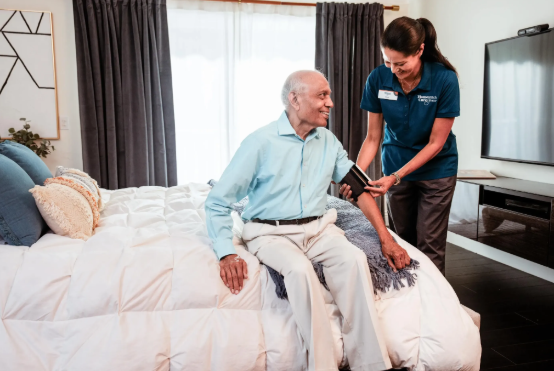 caregiver taking mans blood pressure