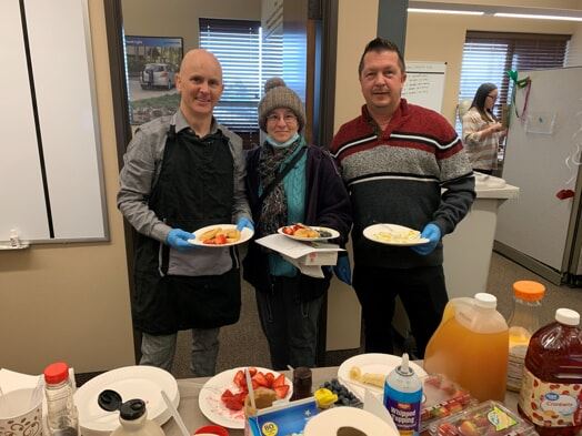 3 people holding plates of food