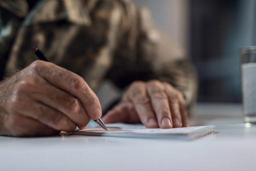 Image of man writing on notepad